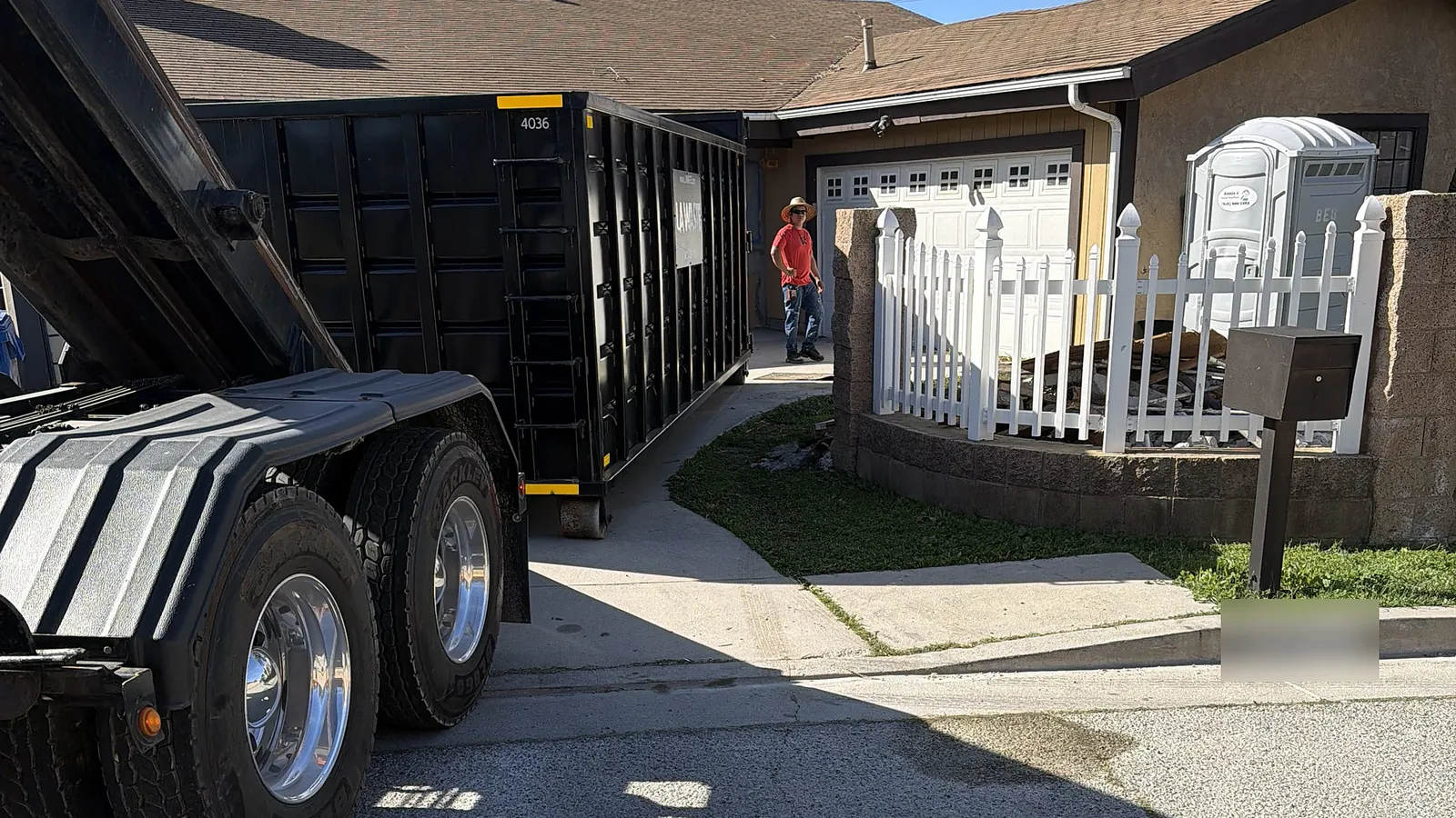 LA Waste roll off truck delivering a 40 yard dumpster to a driveway