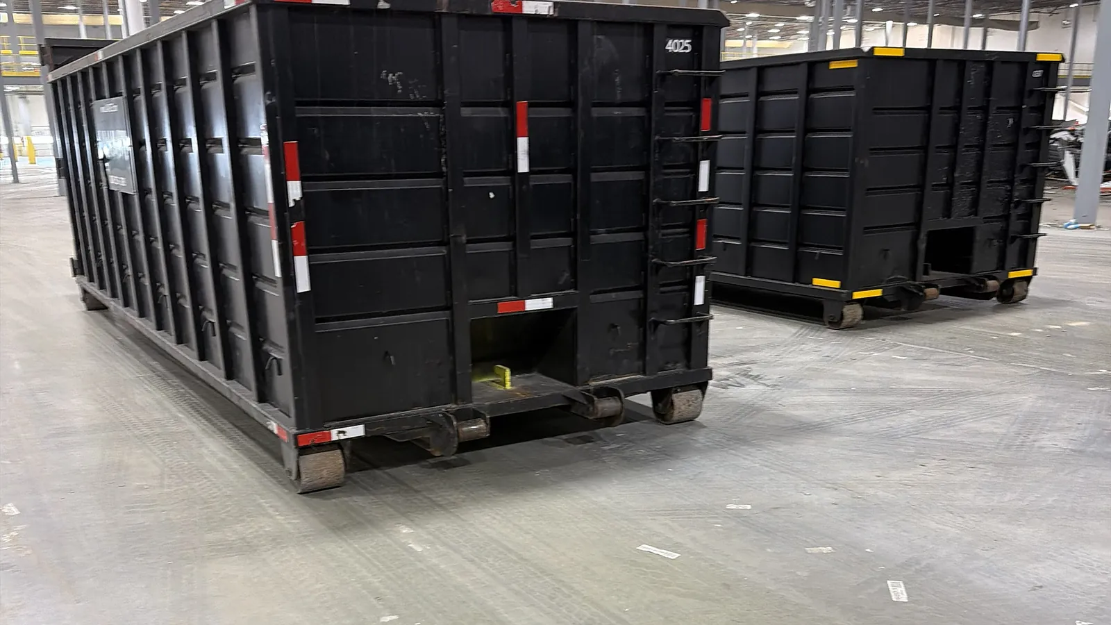 Two LA Waste 40 yard roll off dumpsters staged inside a warehouse